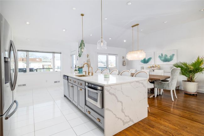 Kitchen featuring visible vents, stainless steel appliances, a sink, light stone counters, and pendant lighting | Image 5