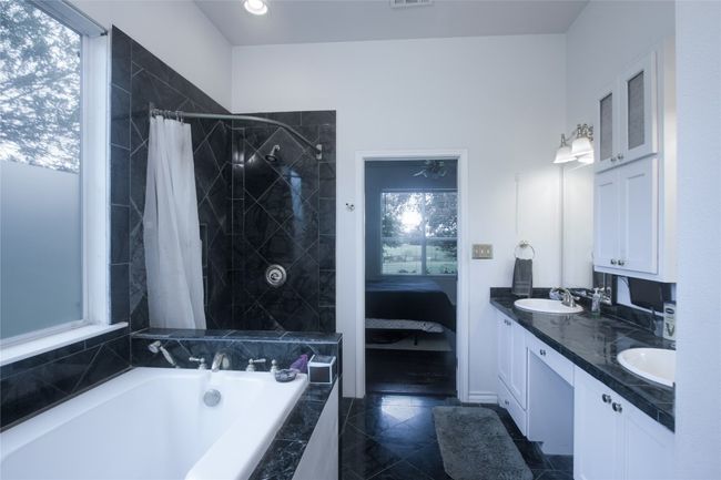 Bathroom featuring a bath, double vanity, ensuite bathroom, and a tile shower | Image 19