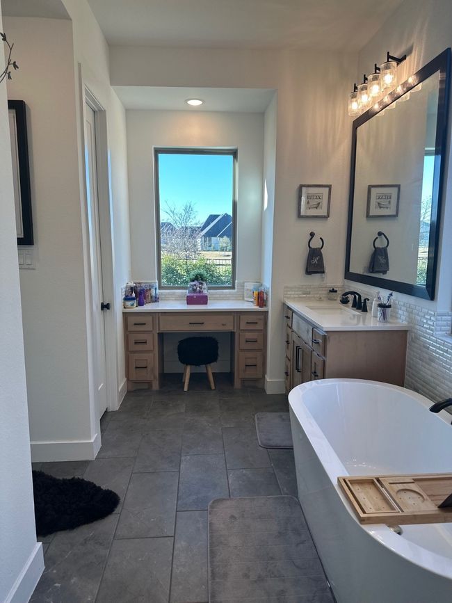 Bathroom with a soaking tub, vanity, and baseboards | Image 25