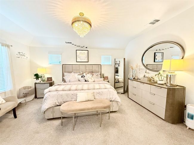 Bedroom with light colored carpet and a chandelier | Image 29