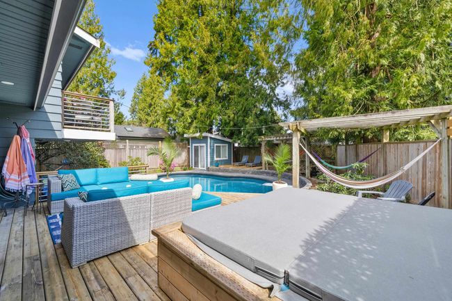 View of pool featuring an outbuilding, a fenced backyard, an outdoor living space, and a deck | Image 32