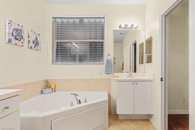 Bathroom with baseboards, a garden tub, and vanity | Image 16