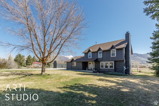 View of front of property with a chimney, brick siding, a front yard, and a mountain view | Image 32