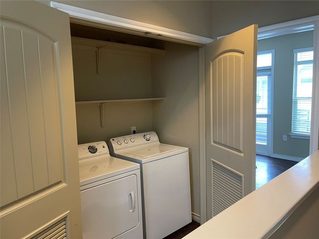 Laundry area with washing machine and dryer and dark wood-style floors | Image 15