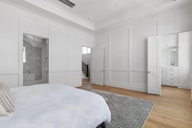The level of superior craftsmanship is clear in this bedroom, from the custom wainscoting to the high ceilings and thoughtfully placed windows, creating a space that feels both expansive and intimate. | Image 21
