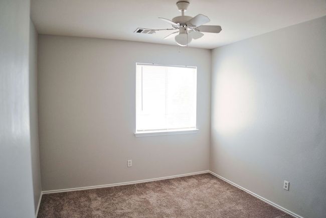 Unfurnished room featuring healthy amount of natural light, ceiling fan, and carpet | Image 24