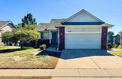 View of front facade with a garage and a front lawn | Image 1