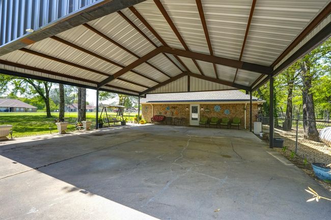 View of vehicle parking featuring a carport and fence | Image 29