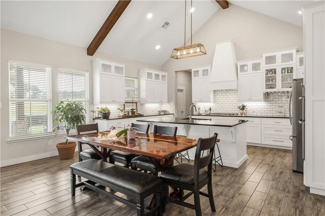 Dining area with beamed ceiling, dark wood-style flooring, recessed lighting, baseboards, and high vaulted ceiling | Image 6