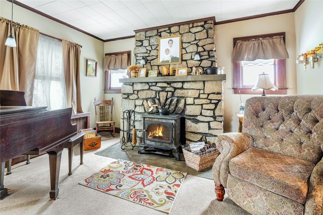 Living area featuring crown molding, a healthy amount of sunlight, and carpet flooring | Image 7