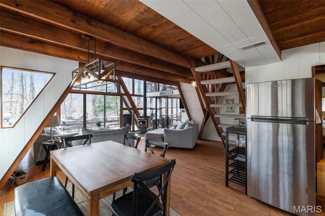 Unfurnished dining area featuring visible vents, beamed ceiling, wood ceiling, and wood finished floors | Image 10
