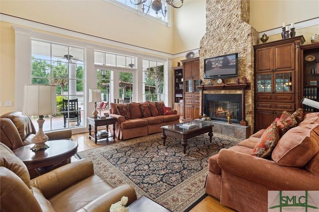 French doors lead out to a huge covered porch with the pool area just beyond. | Image 8