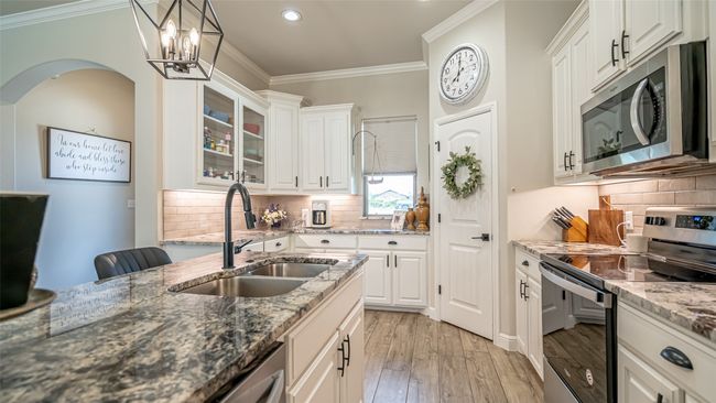 Kitchen featuring granite counter tops, island & breakfast bar, walk-in pantry | Image 8