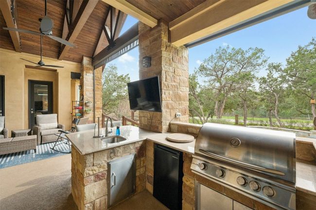 The outdoor kitchen has all the necessities that will make you wish every day was a backyard cookout! If the sun gets too hot, just drop the power shade and keep on grilling! | Image 33