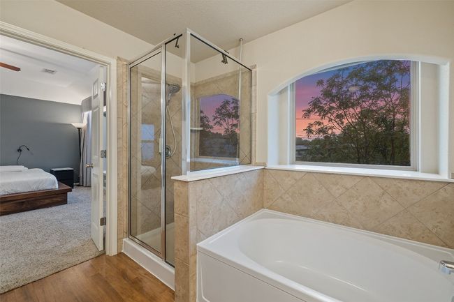 Tranquil primary suite with soundproof windows, automatic blinds, walk in closet, dual vanities, garden tub, walk in shower and private commode. | Image 21