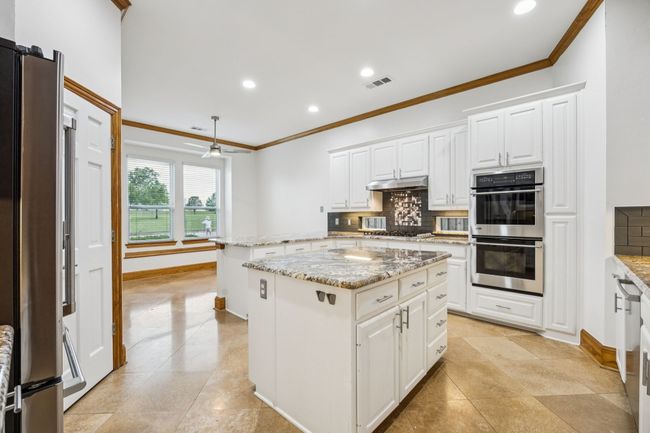 Kitchen with stainless steel appliances, ornamental molding, tasteful backsplash, a center island, and recessed lighting | Image 9