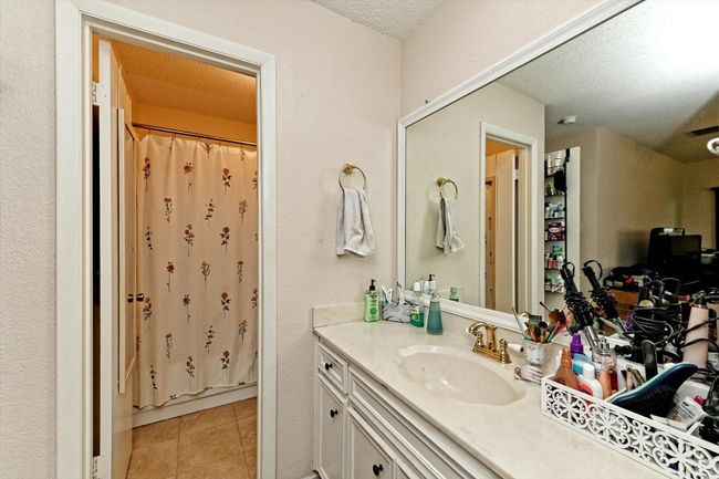 Bathroom featuring tile patterned floors, a shower with shower curtain, vanity, and a textured ceiling | Image 15