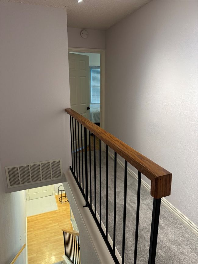 Stairway with a textured ceiling and wood finished floors | Image 12