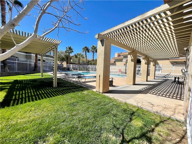 View of yard with a pergola, a patio, a community pool, and fence | Image 48
