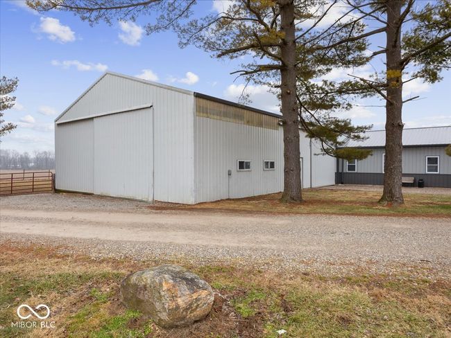 Large barn with concrete flooring next to the guest house. Would be great for parking. Has a loft room, and 3 large slider doors. Screens were made to fit in the openings for the slider doors to allow ventilation while gathering. | Image 62