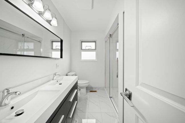 Full bathroom with toilet, a sink, and a marble finish shower | Image 10