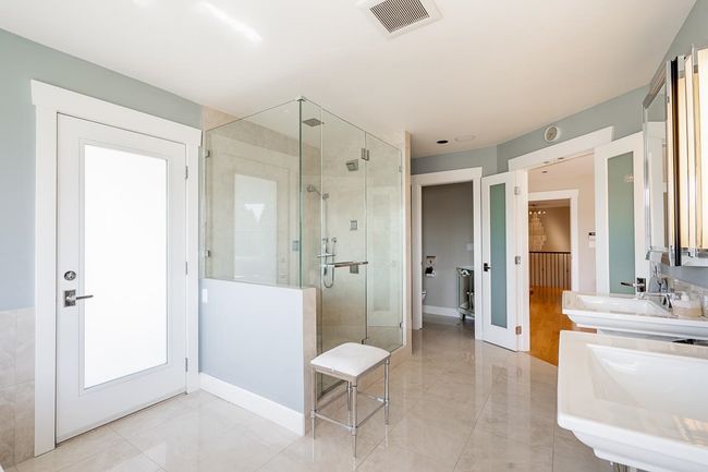 Full bathroom featuring a stall shower, double vanity, and marble finish floors | Image 21
