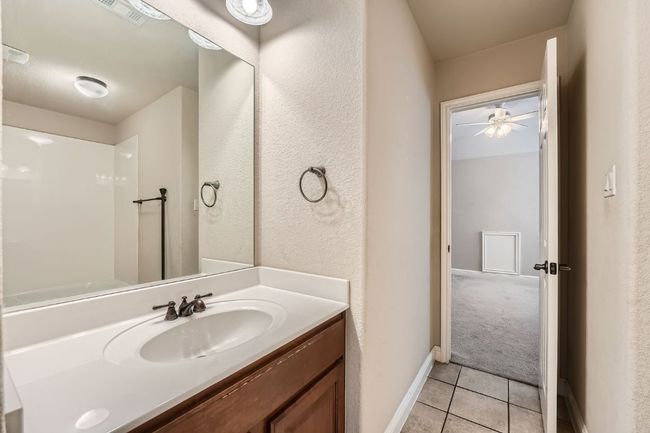 Bathroom featuring tile patterned flooring, vanity, a ceiling fan, baseboards, and visible vents | Image 27