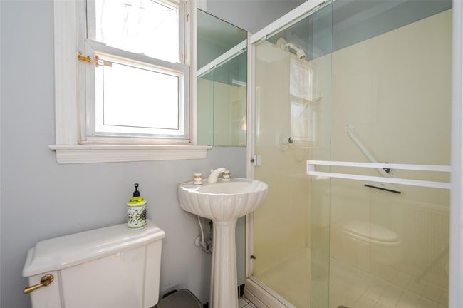 Full bathroom with toilet, a sink, and a stall shower | Image 15