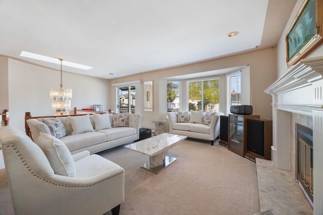 Living room featuring light carpet, an inviting chandelier, and a tile fireplace | Image 10