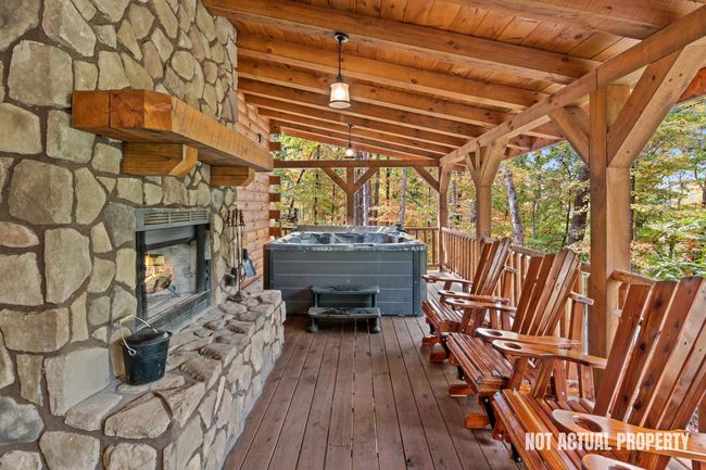Pic from model cabin with hot tub on upper deck and chairs in front of fireplace | Image 10