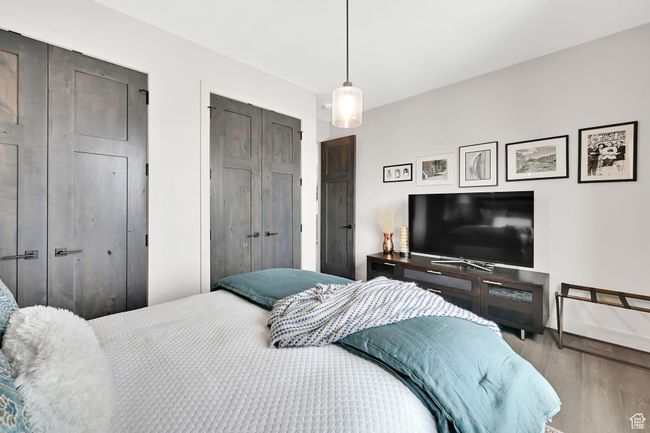 Bedroom with wood finished floors, baseboards, and a closet | Image 52