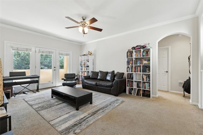 Living area featuring arched walkways, crown molding, ceiling fan, carpet flooring, and french doors | Image 35