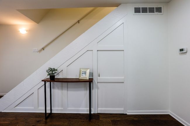 Side of stairs has a door that leads to under stairs storage. | Image 31