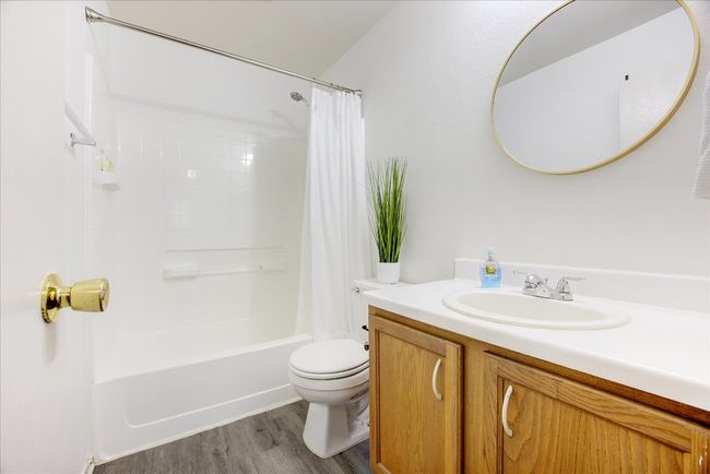 Full bath featuring vanity, shower / bath combination with curtain, and wood finished floors | Image 8