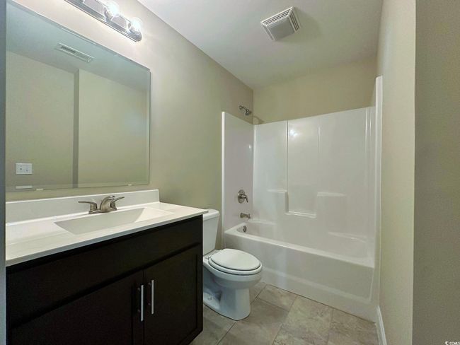 Carpeted empty room with baseboards, visible vents, vaulted ceiling, and a ceiling fan | Image 14