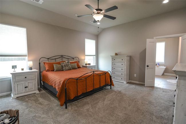 Carpeted bedroom featuring ceiling fan and vaulted ceiling | Image 18