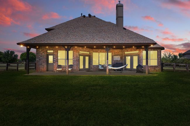 Back of property featuring french doors, a patio area, brick siding, and a chimney | Image 31