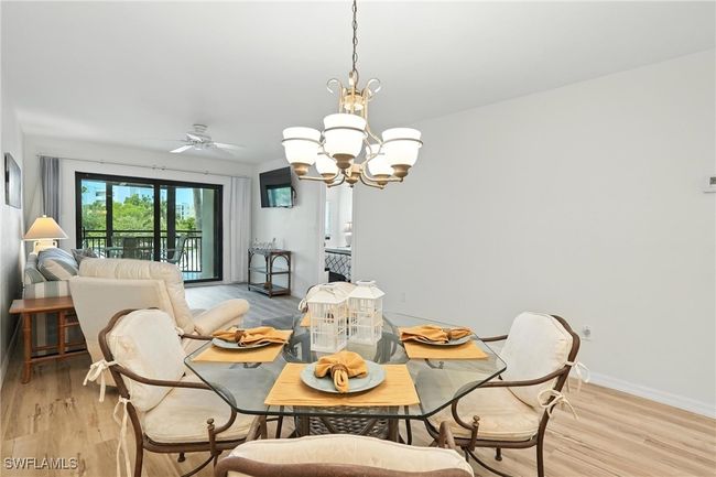 Dining room with a chandelier, light wood-type flooring, and ceiling fan | Image 10
