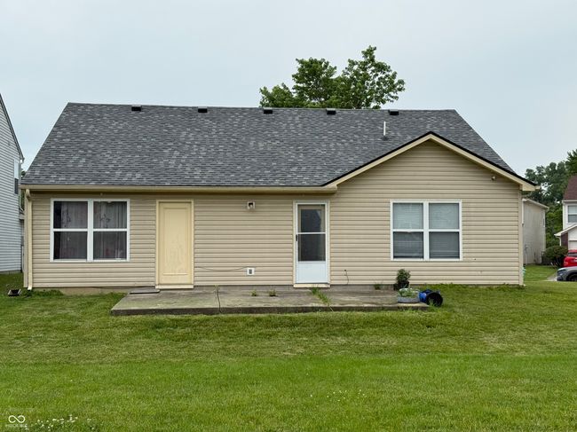 back of house featuring roof with shingles, a yard, and a patio area | Image 16