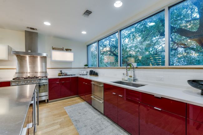 Kitchen with sink, stainless steel gas range oven, light hardwood / wood-style floors, decorative backsplash, and wall chimney range hood | Image 20