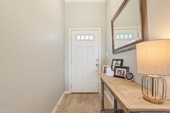 Entryway with light wood-style flooring and a textured wall | Image 7
