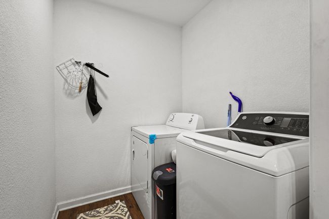 Laundry area featuring independent washer and dryer, wood finished floors, and baseboards | Image 34