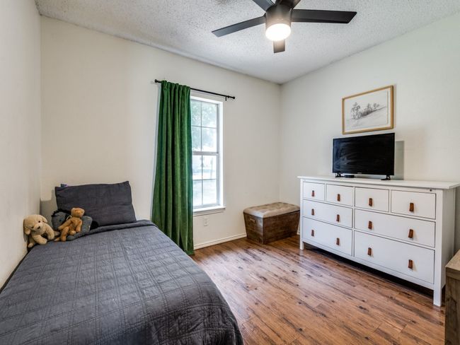 Bedroom with wood finished floors, a textured ceiling, and ceiling fan | Image 16