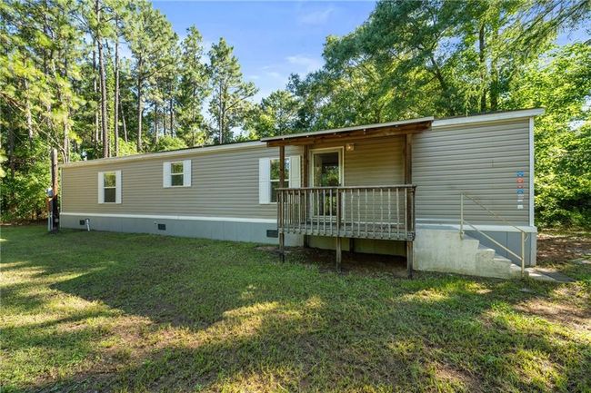 Back of house featuring crawl space, a lawn, and a deck | Image 5