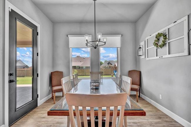 Dining space with light wood-type flooring, baseboards, and a chandelier | Image 22
