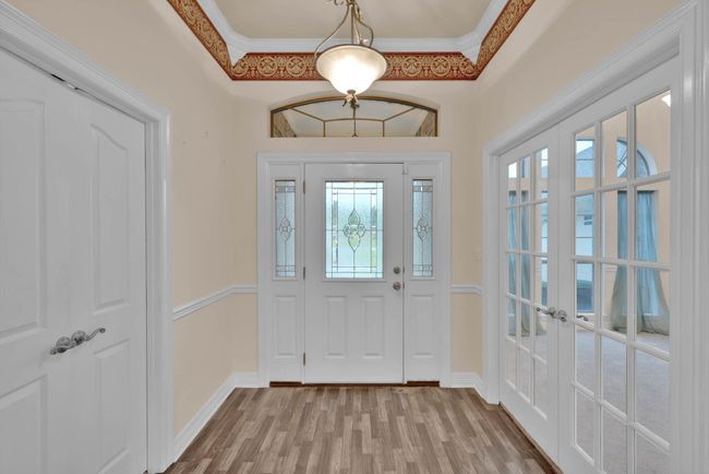 Entrance foyer featuring healthy amount of natural light, french doors, crown molding, and wood finished floors | Image 4