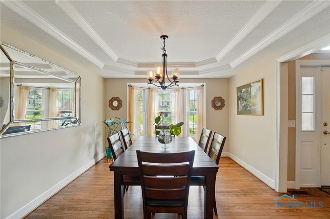 Stunning dining room with tray ceilig and bay windows. | Image 9