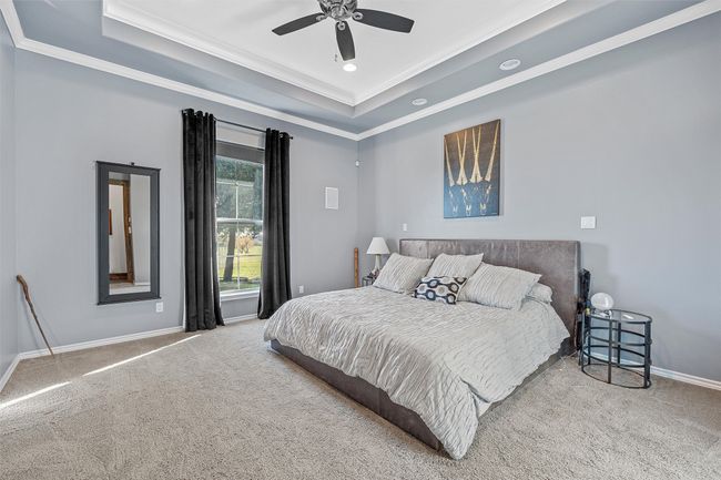 Bedroom featuring a tray ceiling, carpet floors, crown molding, recessed lighting, and a ceiling fan | Image 8