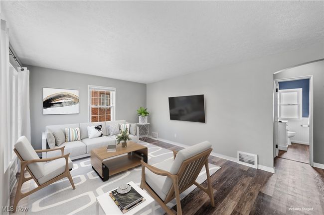 Living room featuring a textured ceiling, dark wood-style flooring, and baseboards | Image 4