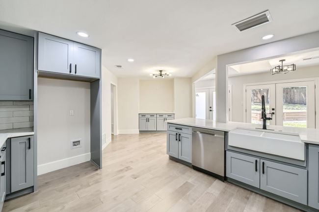 Kitchen with visible vents, gray cabinetry, dishwasher, and a sink | Image 11